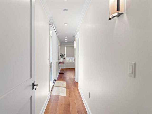 corridor with recessed lighting, baseboards, crown molding, and light wood-style floors