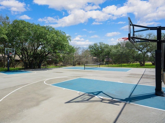 view of basketball court with a tennis court, community basketball court, and fence