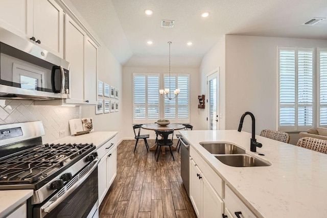 kitchen with visible vents, appliances with stainless steel finishes, decorative backsplash, and a sink