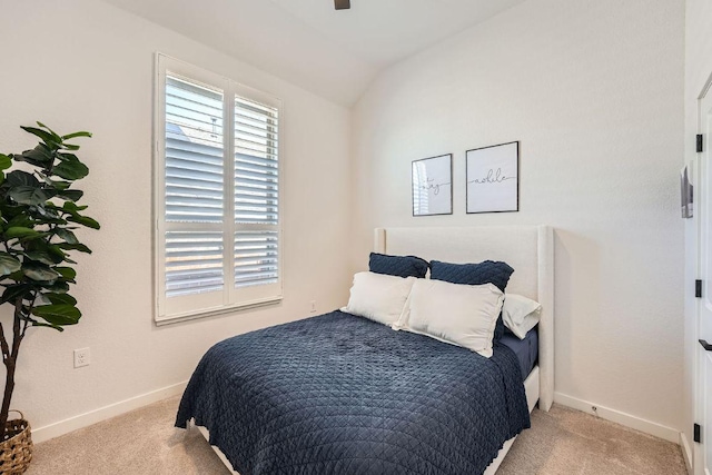 carpeted bedroom featuring vaulted ceiling and baseboards