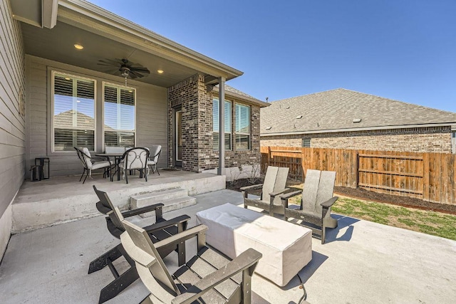 view of patio featuring outdoor dining area, fence, and ceiling fan