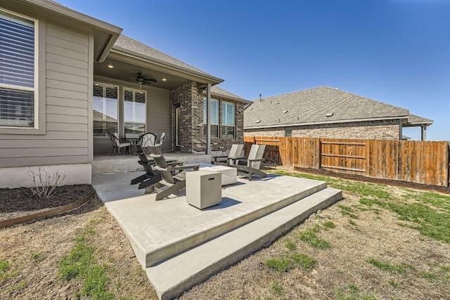 view of patio with an outdoor fire pit, fence, and a ceiling fan