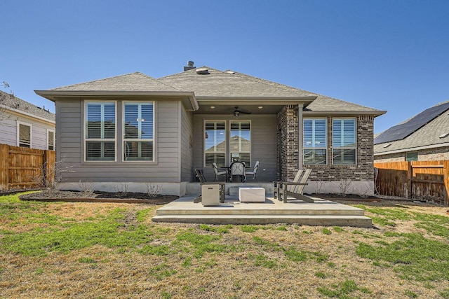 back of house featuring a lawn, a patio area, a fenced backyard, and a ceiling fan