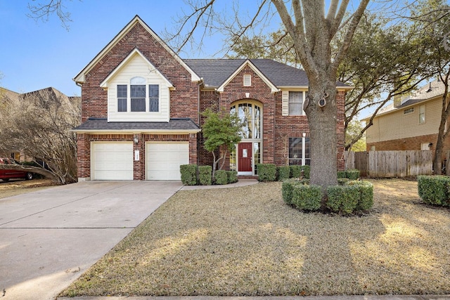 traditional-style house with a garage, a shingled roof, concrete driveway, fence, and brick siding