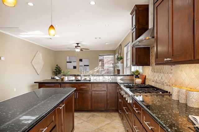 kitchen with crown molding, stainless steel gas cooktop, a sink, a peninsula, and wall chimney exhaust hood