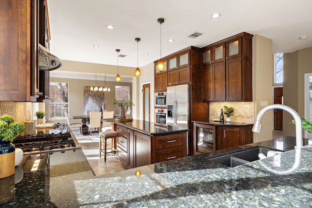 kitchen featuring beverage cooler, visible vents, decorative backsplash, appliances with stainless steel finishes, and a sink