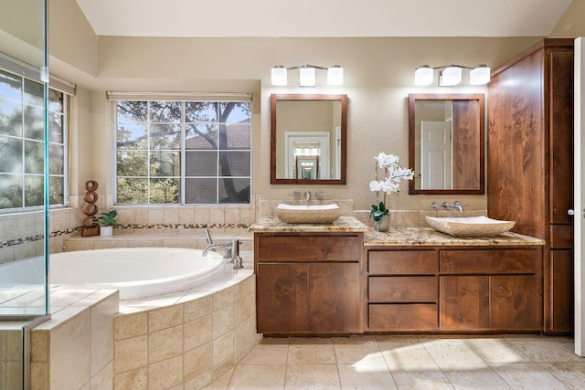 full bathroom with a bath, double vanity, and a sink