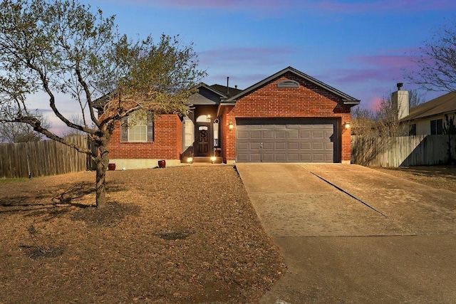 ranch-style house with driveway, brick siding, an attached garage, and fence