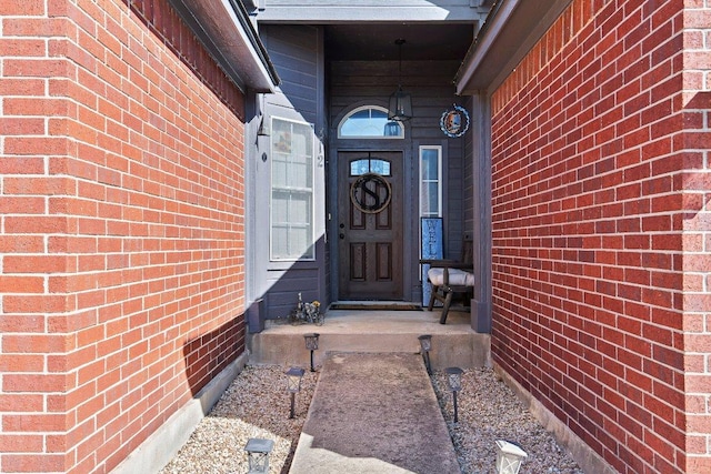 doorway to property with brick siding