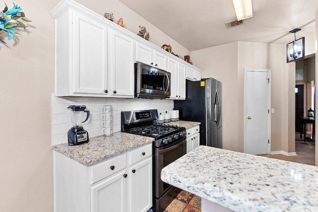 kitchen featuring visible vents, white cabinets, light stone countertops, stainless steel appliances, and backsplash