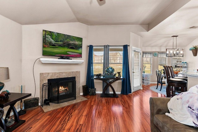 living room with visible vents, wood finished floors, vaulted ceiling, a fireplace, and a chandelier