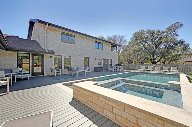 view of swimming pool with a fenced in pool, an in ground hot tub, a deck, and fence