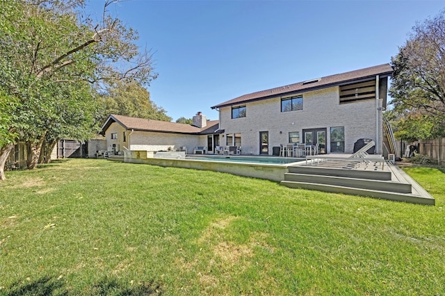 rear view of house with a yard, a fenced backyard, and a fenced in pool