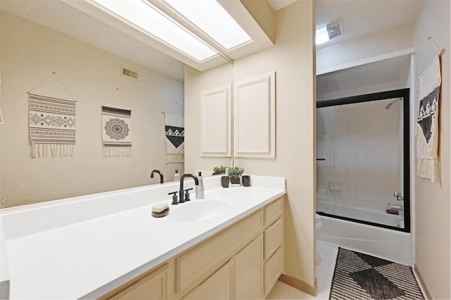 bathroom with vanity, toilet, visible vents, and combined bath / shower with glass door