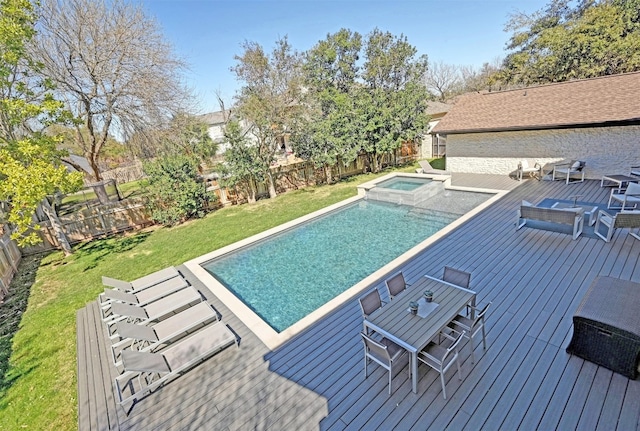 view of pool with a pool with connected hot tub, a lawn, a fenced backyard, and a wooden deck