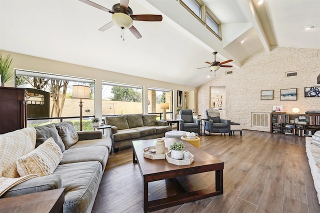 living area featuring beam ceiling, wood finished floors, visible vents, and high vaulted ceiling