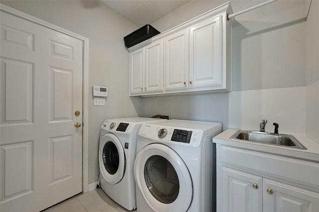 clothes washing area featuring washing machine and dryer, cabinet space, a sink, and light tile patterned flooring