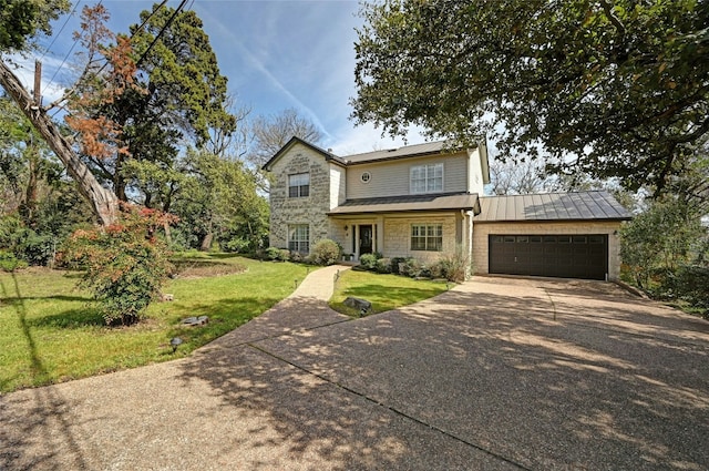 traditional-style house with a front yard, a standing seam roof, metal roof, a garage, and stone siding