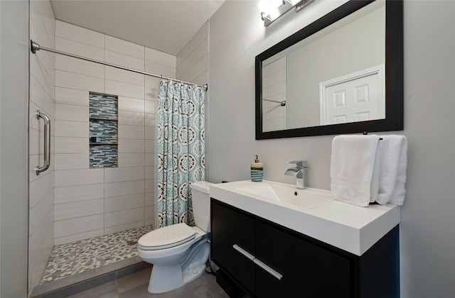 full bath featuring tiled shower, vanity, and toilet