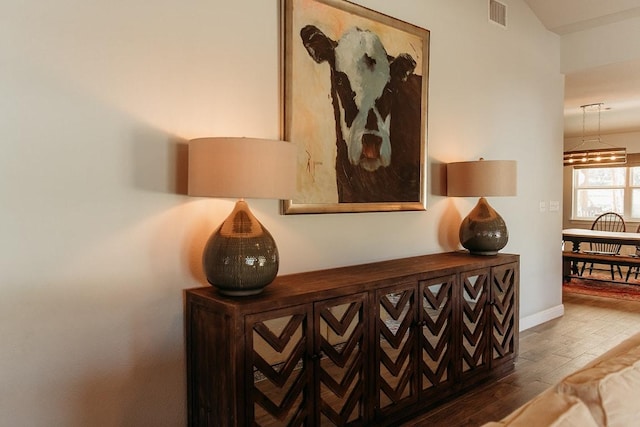 room details featuring visible vents, baseboards, and wood finished floors