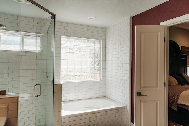 ensuite bathroom featuring tile walls, ensuite bath, a bath, and a shower stall