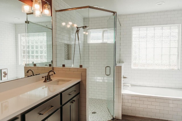 bathroom with a garden tub, vanity, tile walls, decorative backsplash, and a stall shower