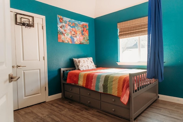 bedroom with baseboards and wood finished floors