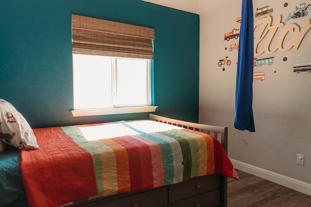 bedroom featuring wood finished floors and baseboards