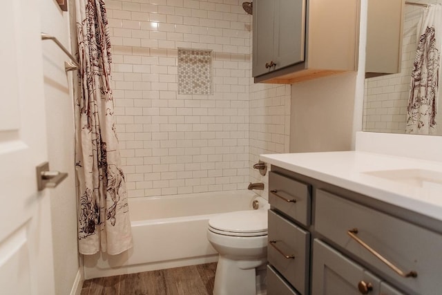full bath featuring shower / tub combo, toilet, vanity, and wood finished floors