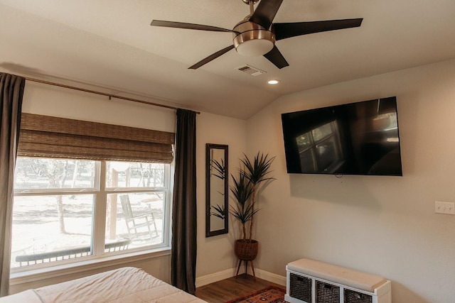 bedroom with baseboards, multiple windows, visible vents, and wood finished floors