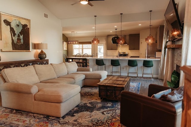 living room with recessed lighting, visible vents, dark wood-type flooring, a ceiling fan, and vaulted ceiling