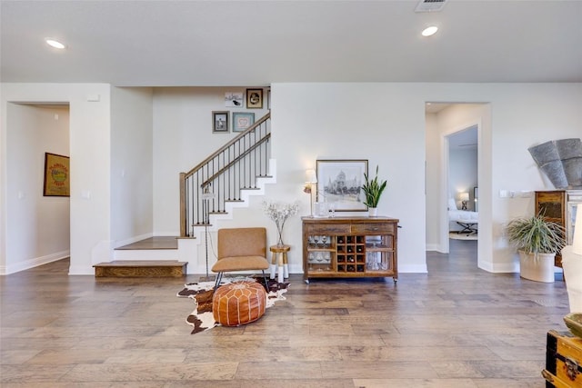 sitting room with stairway, recessed lighting, baseboards, and wood finished floors