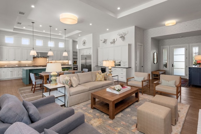 living area with visible vents, wallpapered walls, a tray ceiling, recessed lighting, and wood-type flooring