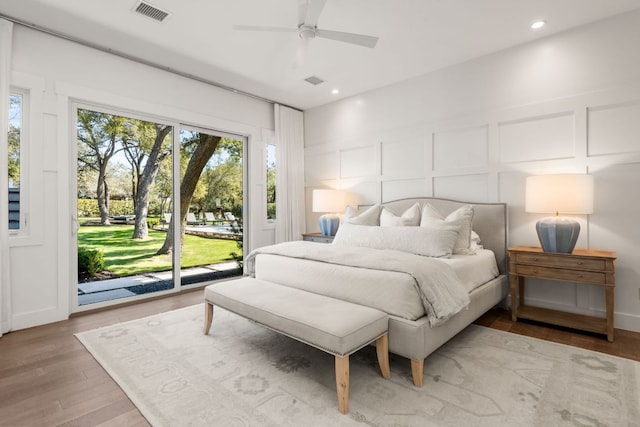 bedroom featuring visible vents, light wood-type flooring, recessed lighting, a decorative wall, and access to outside