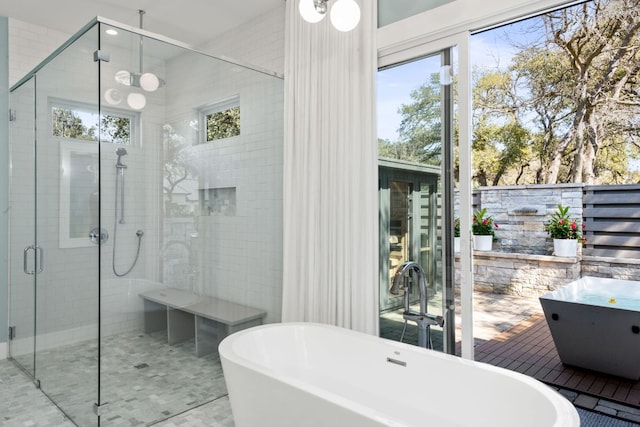 full bathroom featuring a soaking tub, a stall shower, and a sink