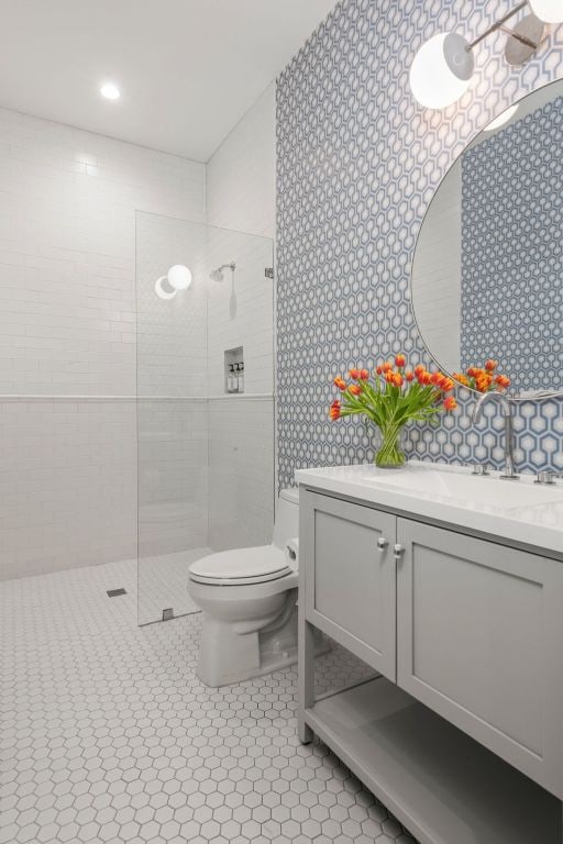 full bathroom with tile patterned flooring, toilet, vanity, and a walk in shower