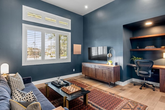 office space featuring baseboards and light wood finished floors