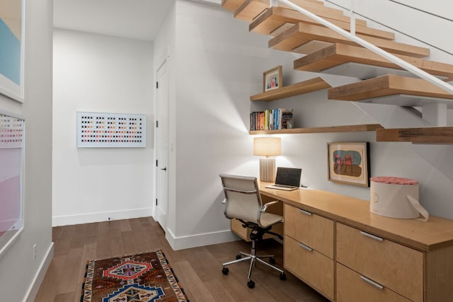 home office featuring built in desk, baseboards, and dark wood-style flooring