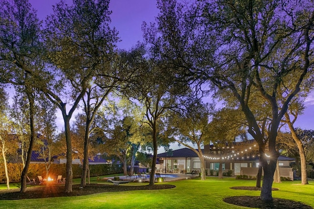 view of community with a swimming pool, a lawn, and a patio area