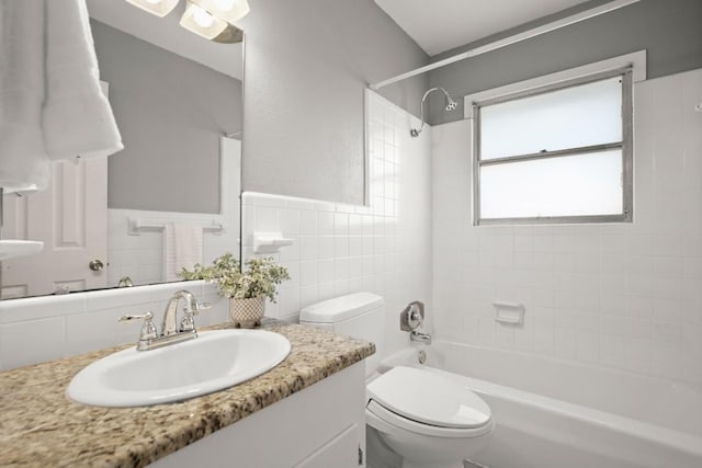 611 Virginia Dr, Round Rock, TX 78664 - bathroom featuring vanity, bathing tub / shower combination, toilet, tile walls, and wainscoting