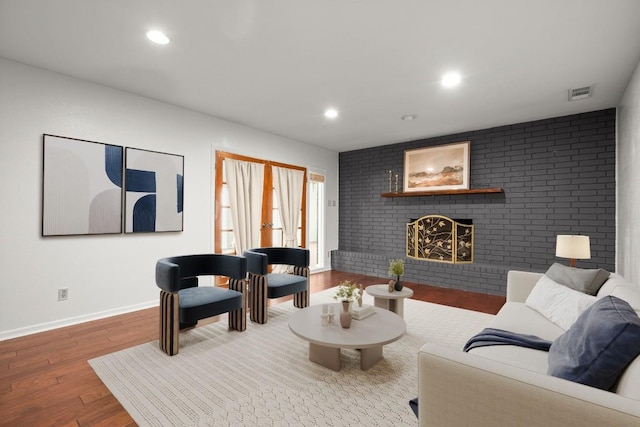 living room featuring visible vents, wood finished floors, french doors, a brick fireplace, and recessed lighting