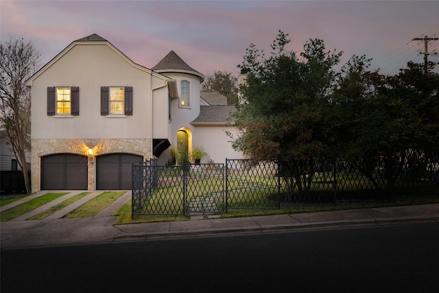 view of front of property with fence, driveway, an attached garage, stucco siding, and stone siding