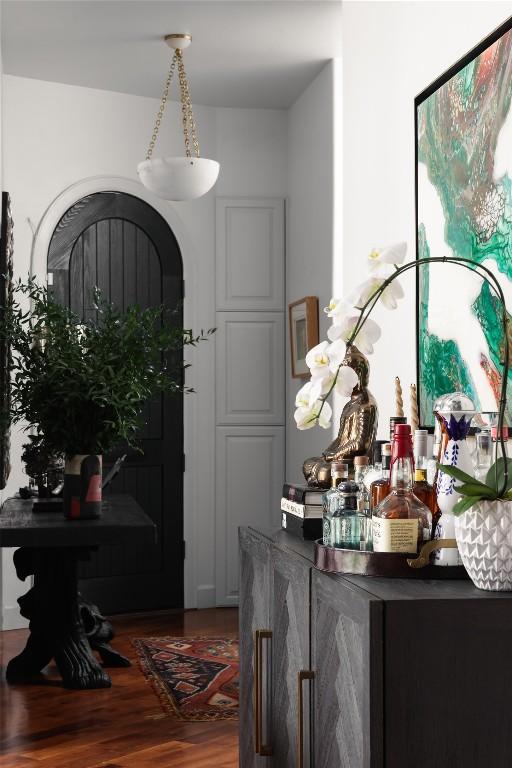 foyer entrance featuring wood finished floors and a dry bar