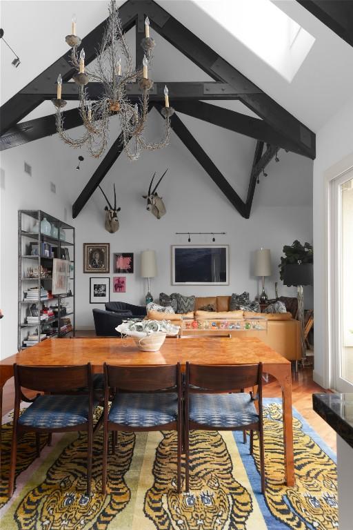 interior space featuring beamed ceiling, high vaulted ceiling, and a skylight