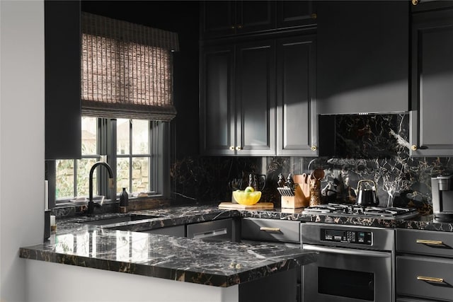 kitchen featuring tasteful backsplash, stainless steel oven, dark stone countertops, dark cabinetry, and a sink