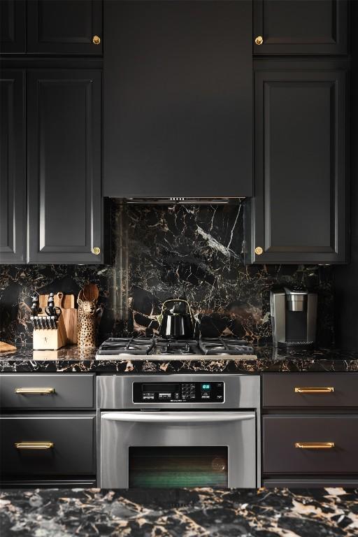 kitchen featuring gas cooktop, dark stone countertops, tasteful backsplash, and oven