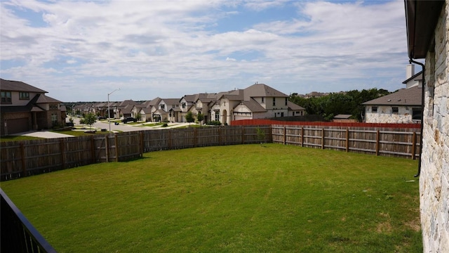 view of yard featuring a fenced backyard and a residential view