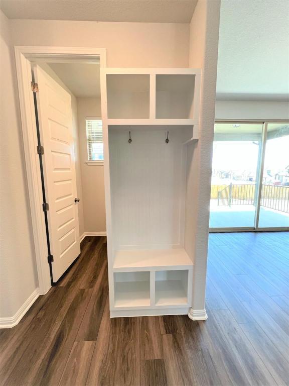 mudroom featuring dark wood finished floors and baseboards