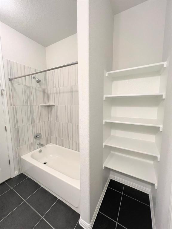 bathroom with tile patterned flooring, baseboards, and tub / shower combination