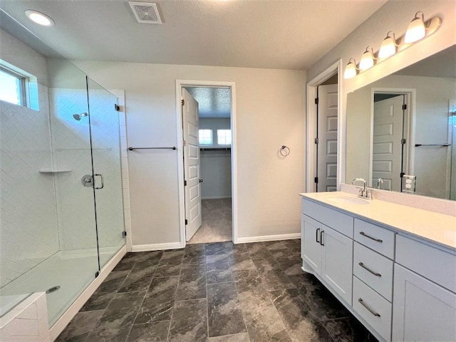 bathroom with vanity, a shower stall, visible vents, and baseboards